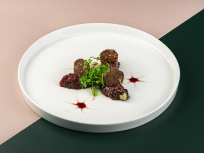 Тартар из вырезки оленя с голубикой,  маринованным в малиновом уксусе  красным луком, листьями мелиссы  и можжевеловым соусом